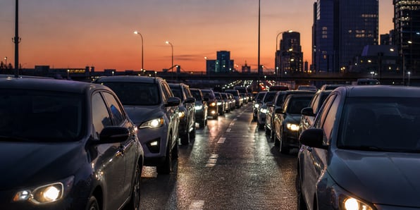 cars-sitting-in-two-lanes-of-traffic-city-in-background