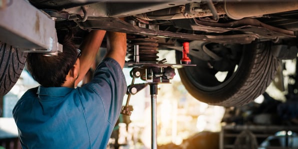 A person reaches into the bottom of a suspended vehicle
