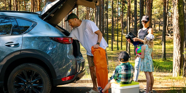 family-loading-gear-into-suv-for-outdoor-trip